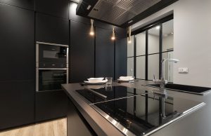 Muebles de cocina negros, placas de cocina y grifo