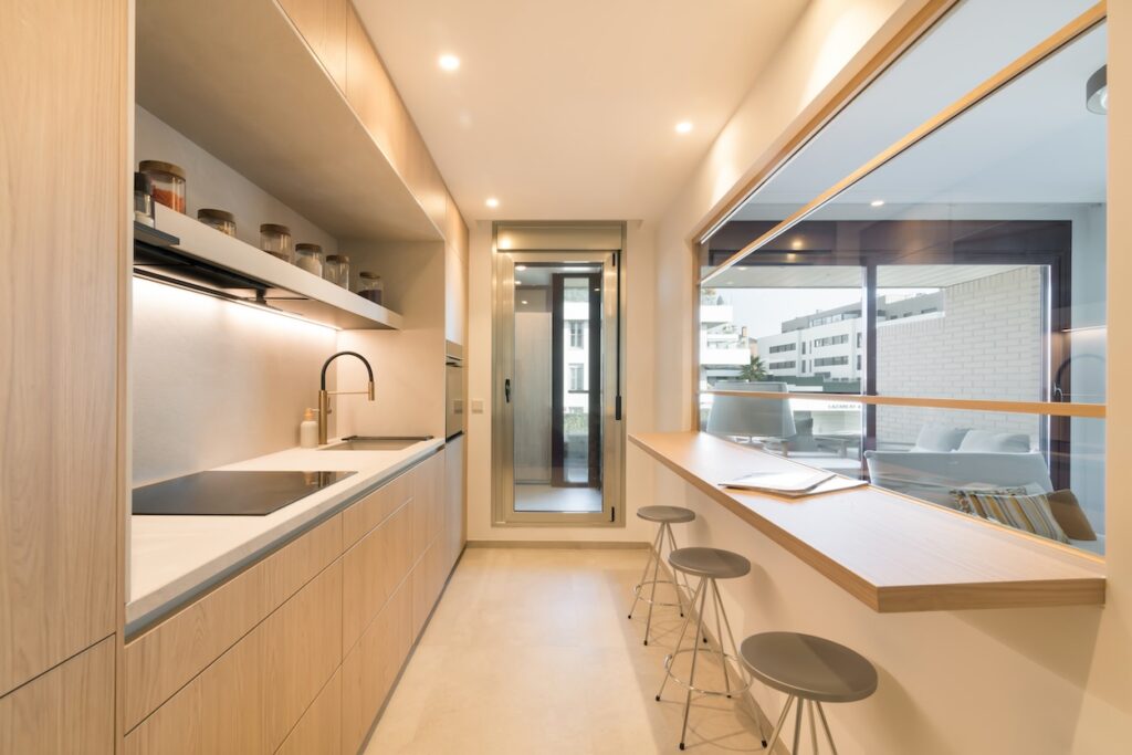 Este proyecto de cocina Santos destaca por su diseño moderno y elegante, pensado para optimizar el espacio y la funcionalidad en un entorno acogedor y luminoso. Se ha optado por muebles en acabado de madera clara